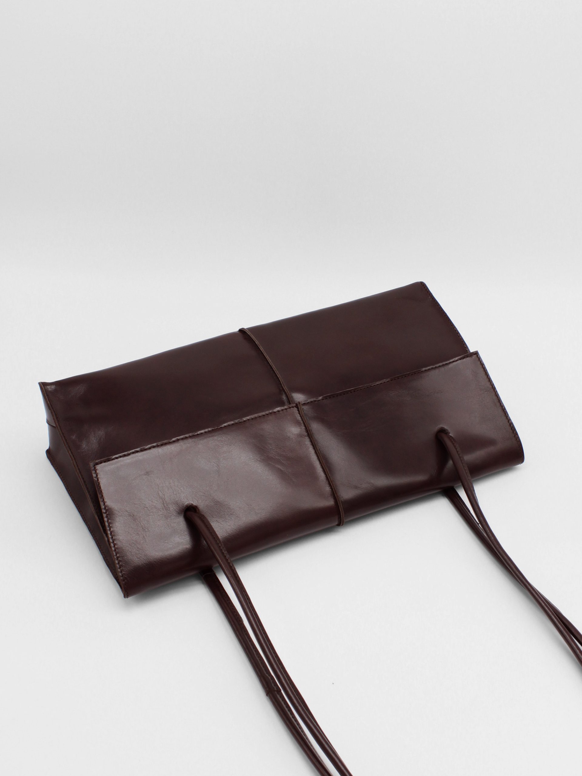 Big rectangle leather shoulder bag with string straps in brown