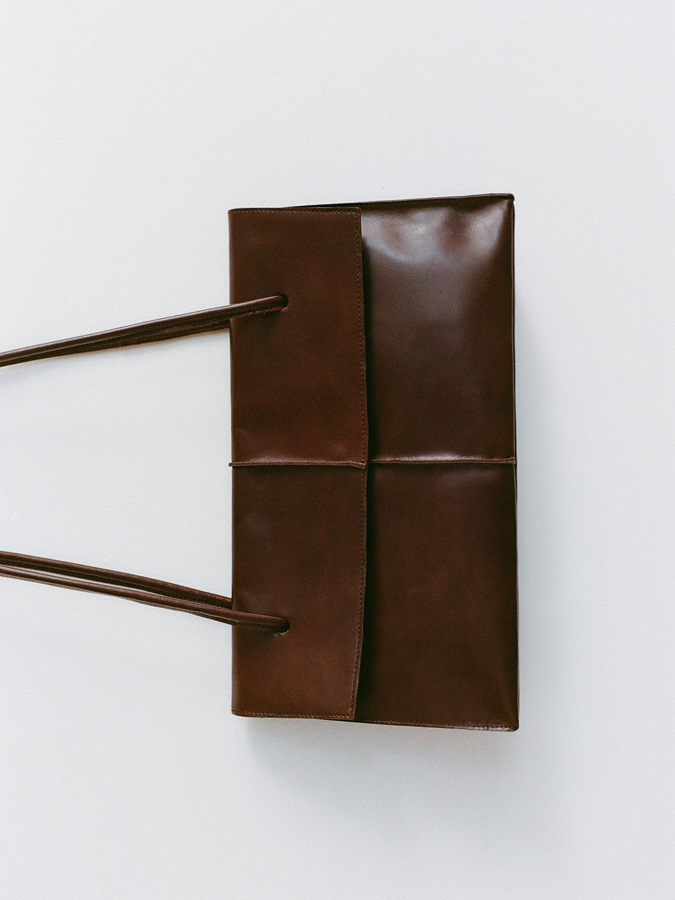 Big rectangle leather shoulder bag with string straps in brown